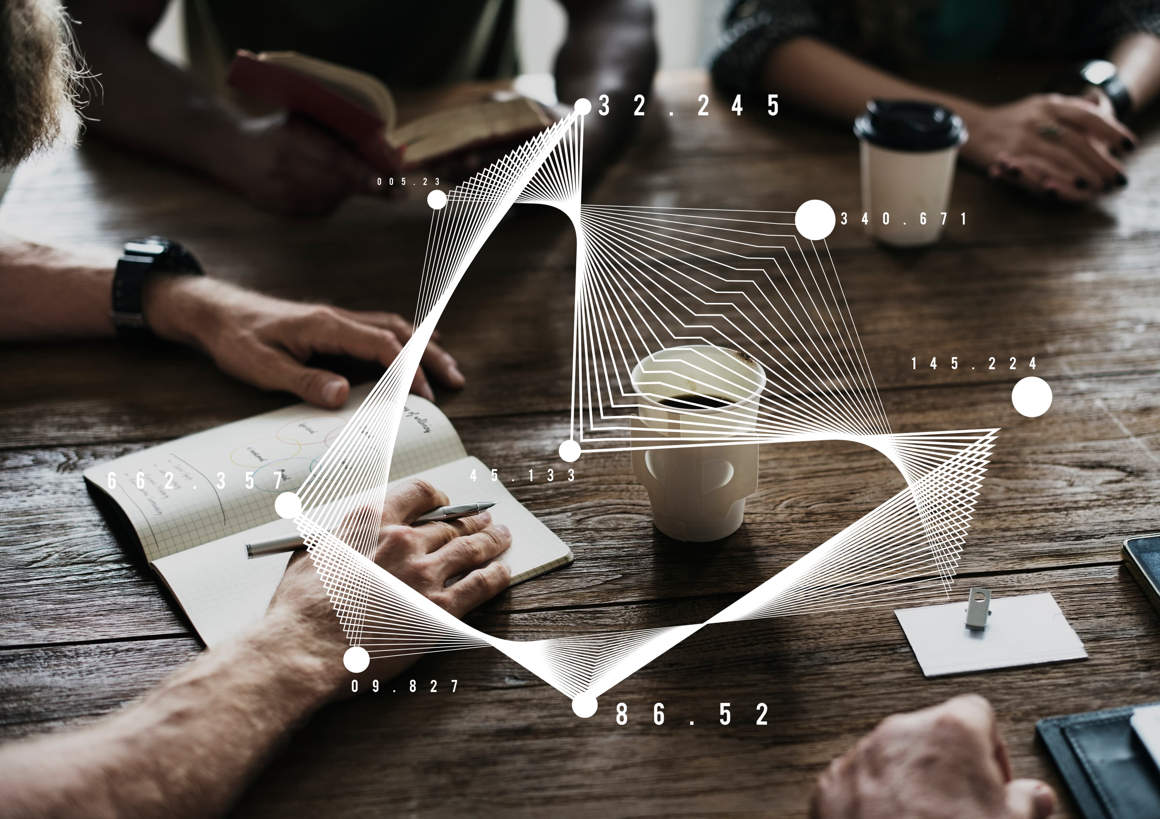 Handen van overleggende mensen aan een houten tafel met notitieboek en koffie, met witte datagraphic eroverheen